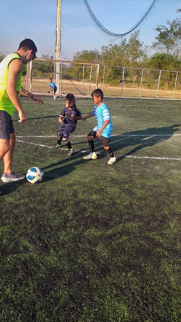 Children playing football at a school sports session in Thailand