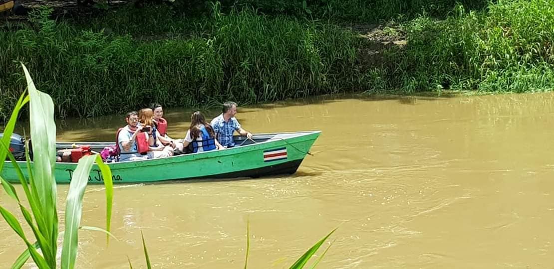Volunteers travelling by boat along a river in Limón, Costa Rica