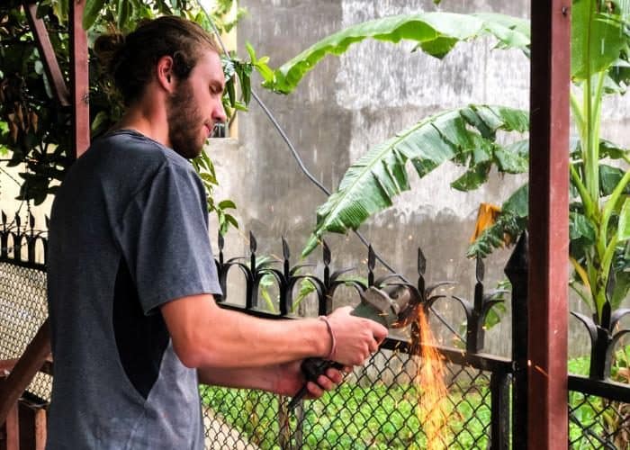 Volunteer cutting metal for a renovation project in Kathmandu