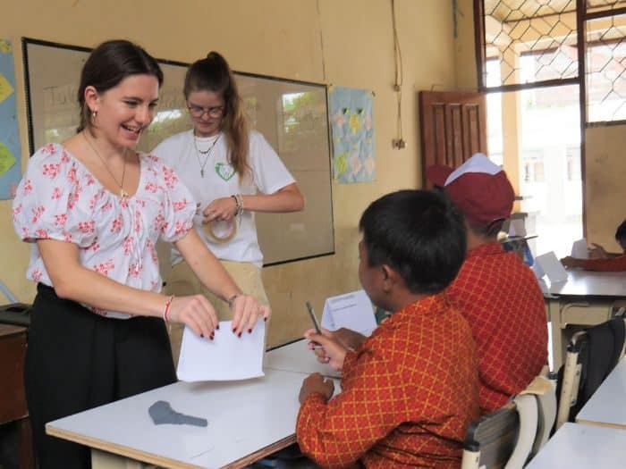 Volunteers assisting a student in a Lombok classroom