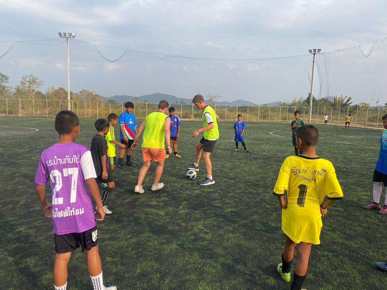 Kids playing football on a sports coaching volunteer program in Thailand