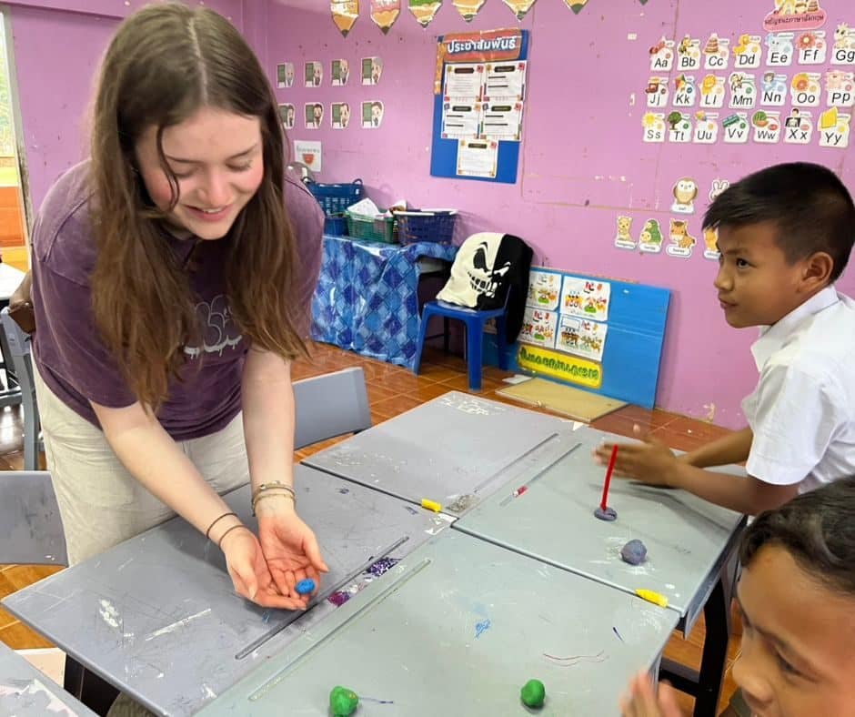 Volunteer teaching a young student during an English lesson in Thailand